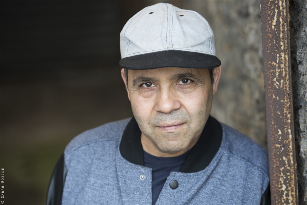 Kamel Benchemekh as the grocer